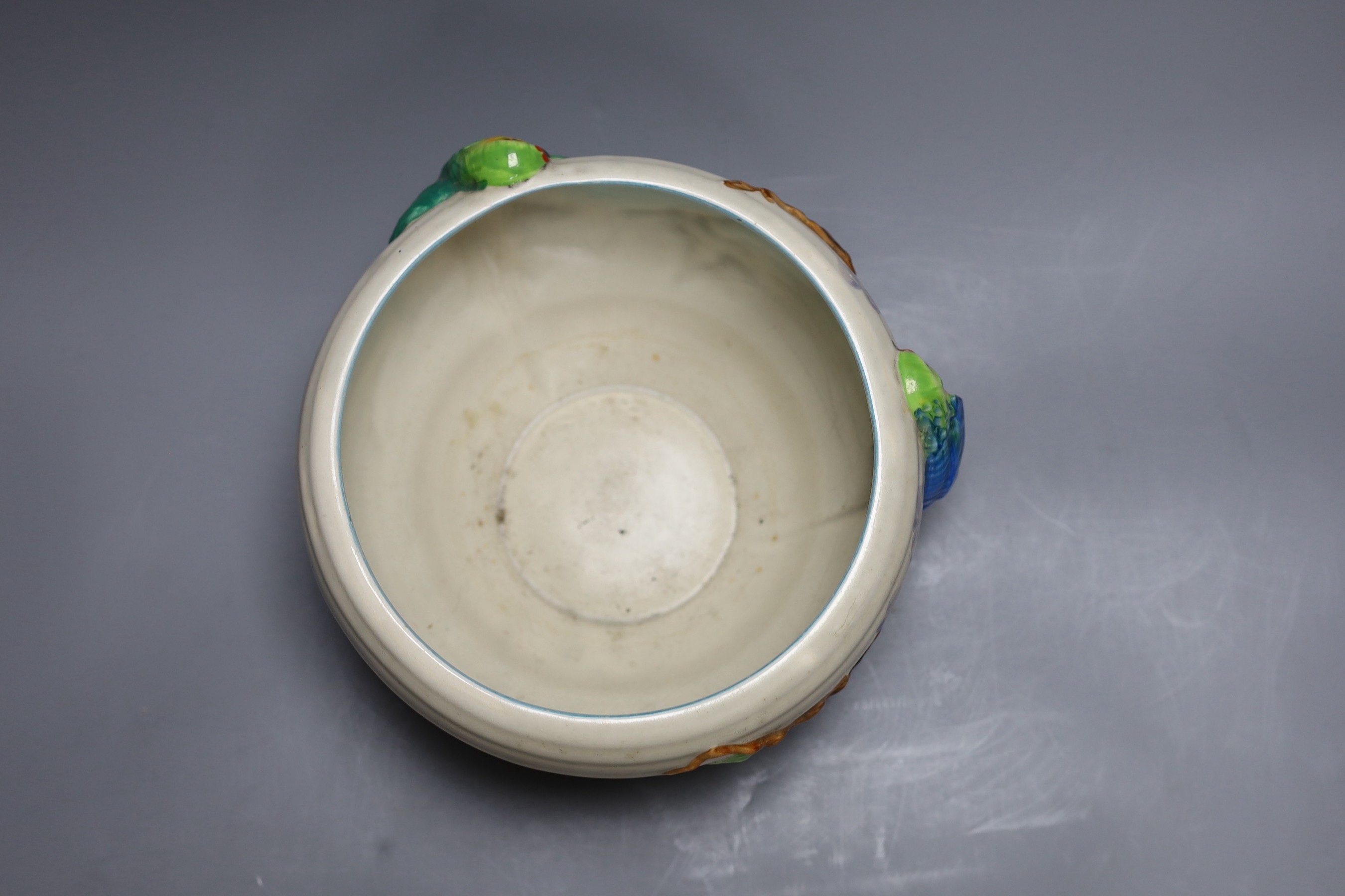 A late Clarice Cliff bowl with perched parrot decoration, 12cm tall